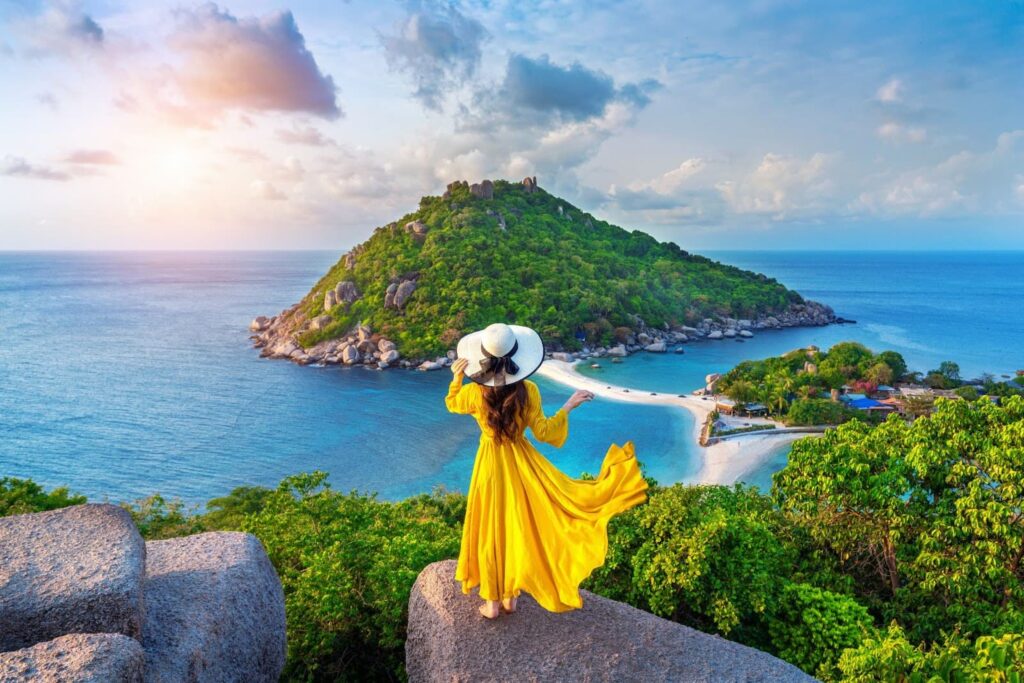 Woman in yellow dress standing on viewpoint at island