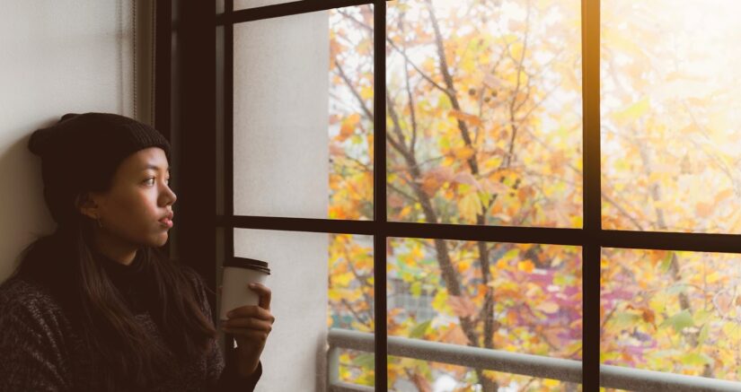 Woman sitting by the window with coffee