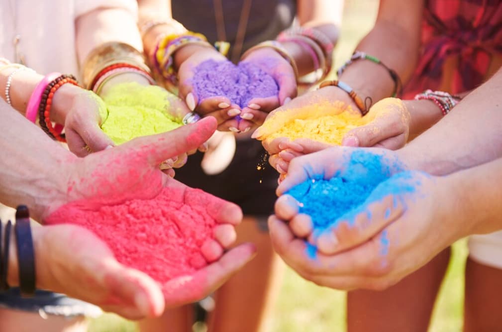 Hands holding colorful powders at Holi festival
